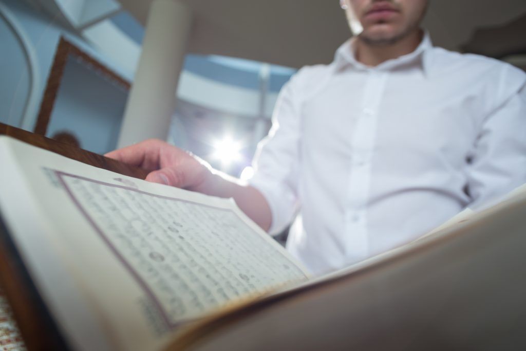 Чтение Корана от колдовства. Man reading Quran. A Muslim is reading the Koran. Чтение корана очищение